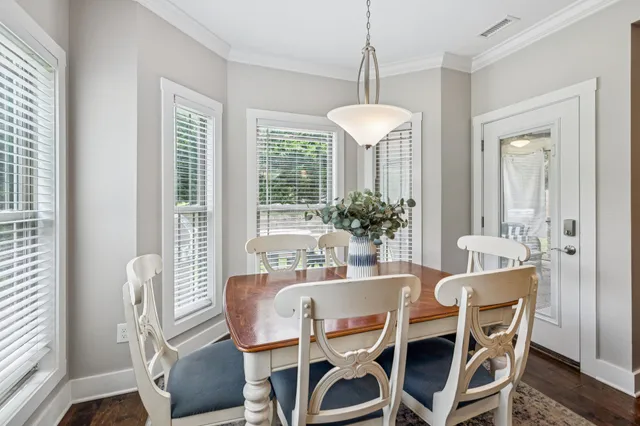 a dining room with furniture a chandelier and wooden floor