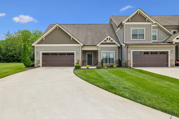 a front view of a house with a yard and garage