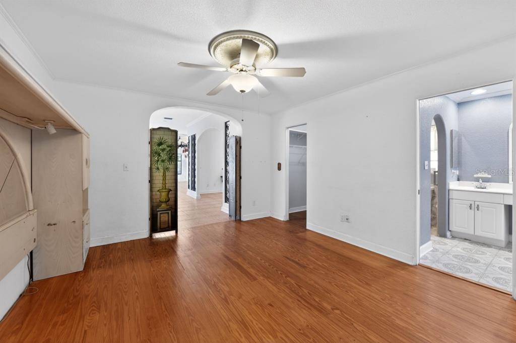 328 Sorrento Street Venice, FL 34285 - Photo 21 of 49 a view of an empty room with wooden floor and a kitchen