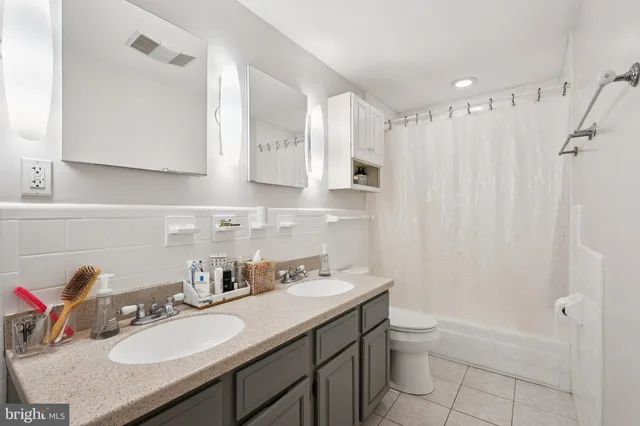 a bathroom with a granite countertop sink toilet a mirror and shower