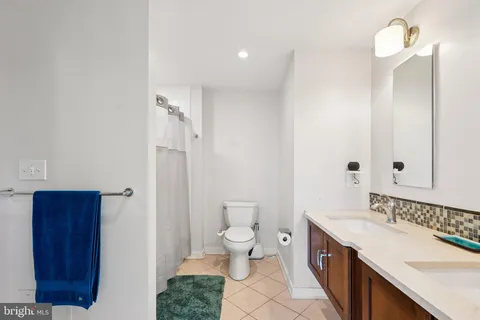 a spacious bathroom with a toilet a sink and a large mirror