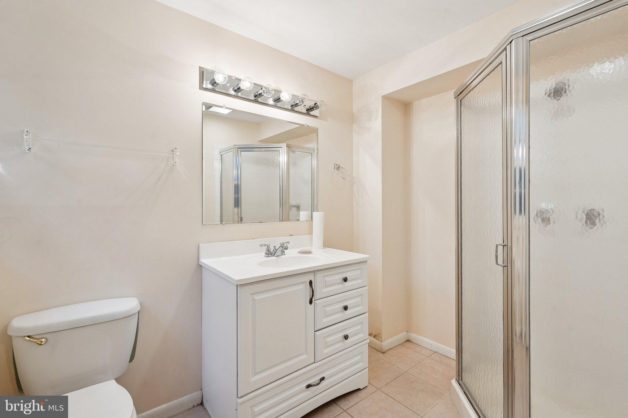 1432 Crestridge Drive Silver Spring, MD 20910 - Photo 32 of 52 a bathroom with a toilet a sink a mirror a vanity and shower