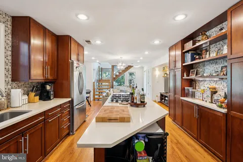 a kitchen with stainless steel appliances granite countertop sink microwave and wooden floor