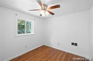 an empty room with a window and a fan