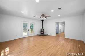 a view of a room with wooden floor and a ceiling fan