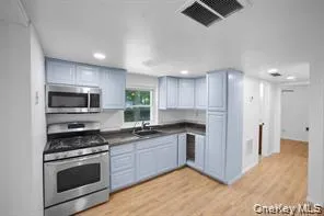 a kitchen with stainless steel appliances kitchen island granite countertop a stove and a sink