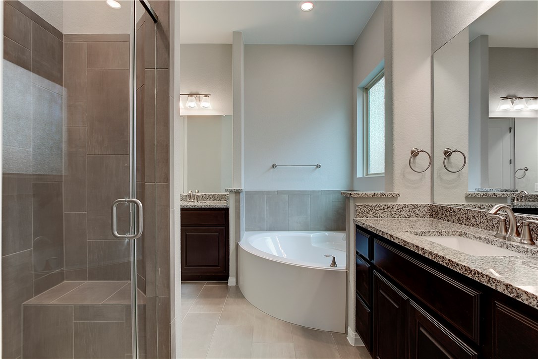 107 Cartwheel Bend Austin, TX 78738 - Photo 8 of 16 Full bath with two vanities, a shower stall, a bath, light tile patterned floors, and recessed lighting
