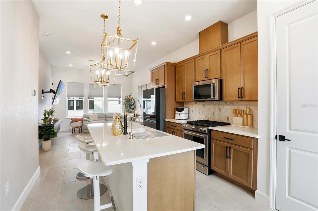 2038 Packing District Way Orlando, FL 32804 - Photo 12 of 39 a kitchen with stainless steel appliances kitchen island granite countertop a kitchen island hardwood floor and a sink