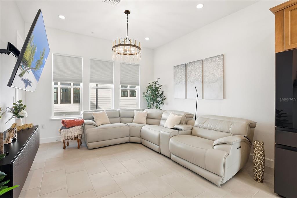 2038 Packing District Way Orlando, FL 32804 - Photo 16 of 39 a living room with furniture a flat screen tv and a window