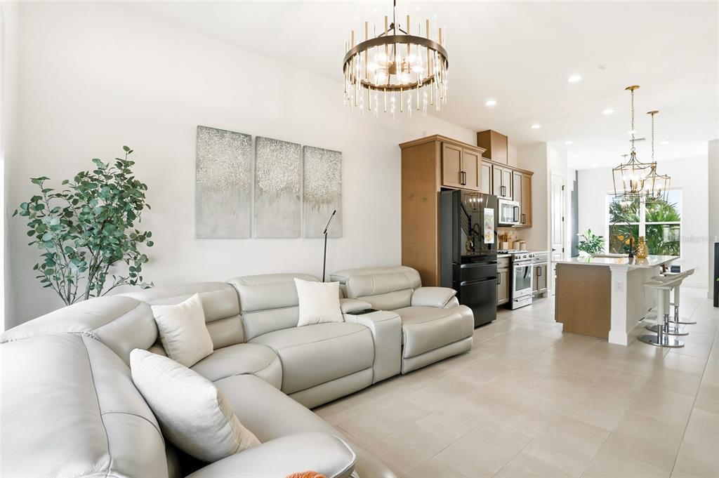2038 Packing District Way Orlando, FL 32804 - Photo 17 of 39 a living room with furniture kitchen and a chandelier