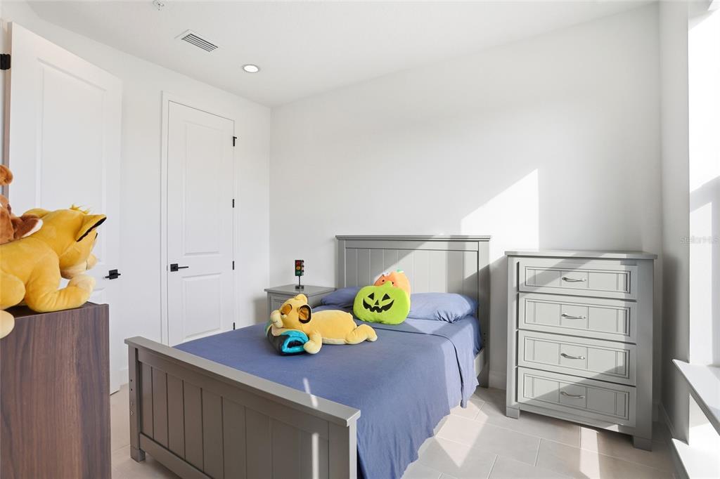 2038 Packing District Way Orlando, FL 32804 - Photo 24 of 39 a bedroom with a bed and a dresser