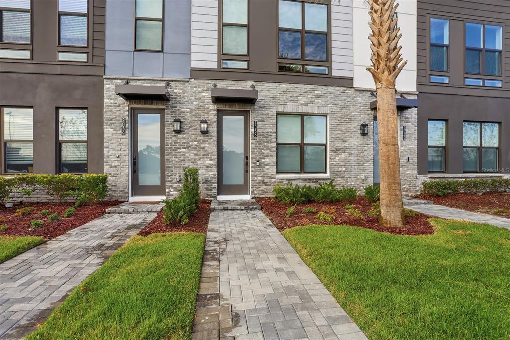 2038 Packing District Way Orlando, FL 32804 - Photo 39 of 39 a front view of a brick house with a yard and potted plants
