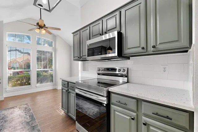 a kitchen with stainless steel appliances a stove microwave and cabinets