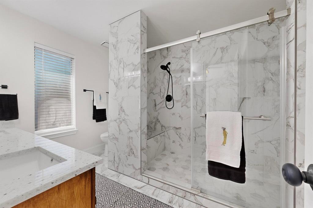 2601 Daisy Lane Rowlett, TX 75089 - Photo 23 of 36 a bathroom with a granite countertop shower a mirror and a sink