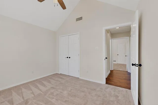 an empty room with chandelier fan