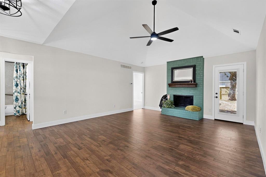 2601 Daisy Lane Rowlett, TX 75089 - Photo 8 of 37 a view of empty room with wooden floor fireplace and window