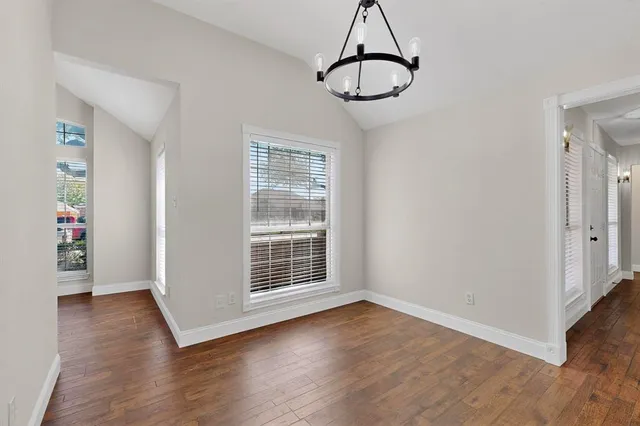 a view of empty room with wooden floor and window