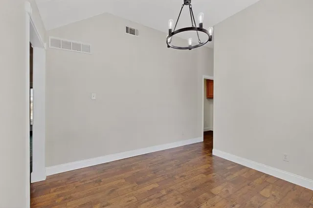 a view of a room with wooden floor and white walls