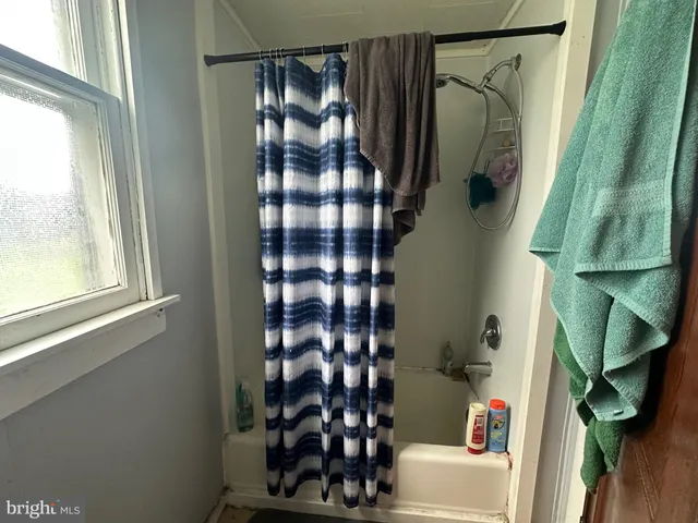 a bathroom with a shower curtain and a window