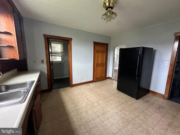 a view of a kitchen with refrigerator and window