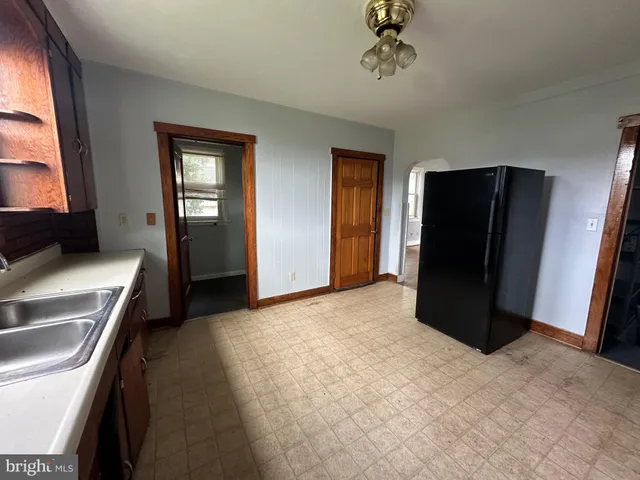 a view of a kitchen with refrigerator and window
