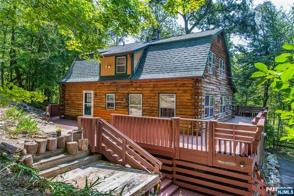 a view of a house with a wooden deck and furniture
