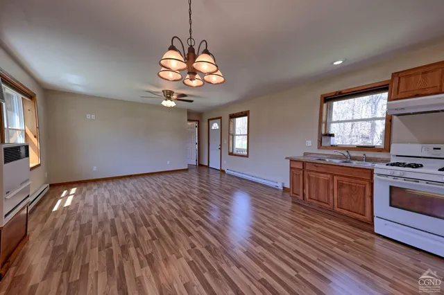 a kitchen with a wooden floor and stainless steel appliances