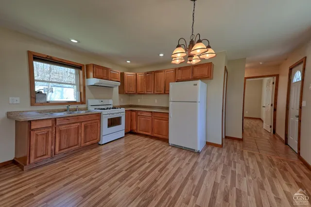a kitchen with stainless steel appliances granite countertop wooden floors and white cabinets