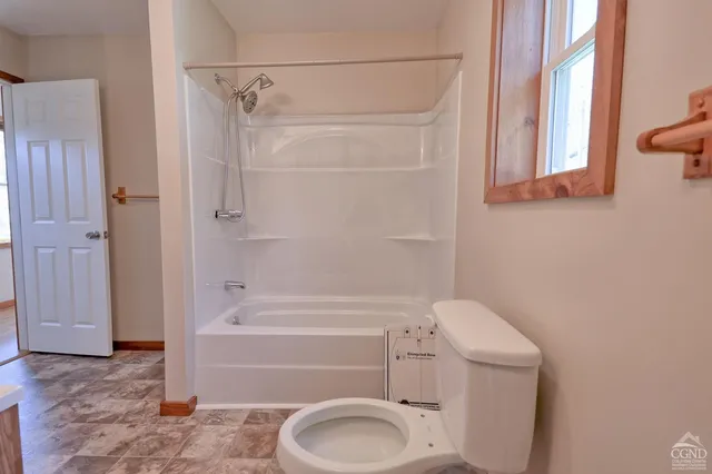 a bathroom with a toilet and a shower