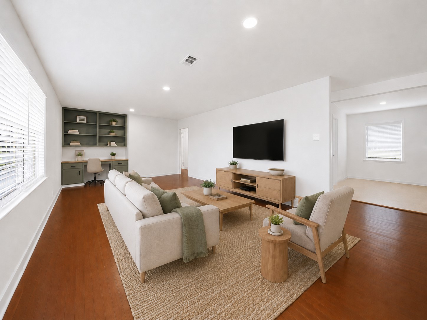 5443 Randon School Road Rosenberg, TX 77471 - Photo 2 of 20 Spacious family room with warm wood flooring, bright white walls, recessed lighting, and built-in shelving with desk space.