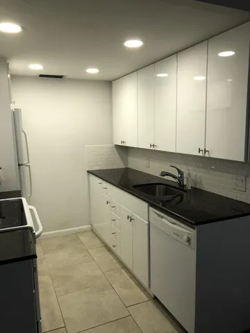 a kitchen with granite countertop a sink and a stove