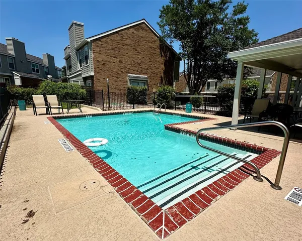 a view of a backyard with a patio and swimming pool