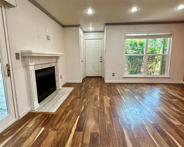 a view of a livingroom with wooden floor and a fireplace