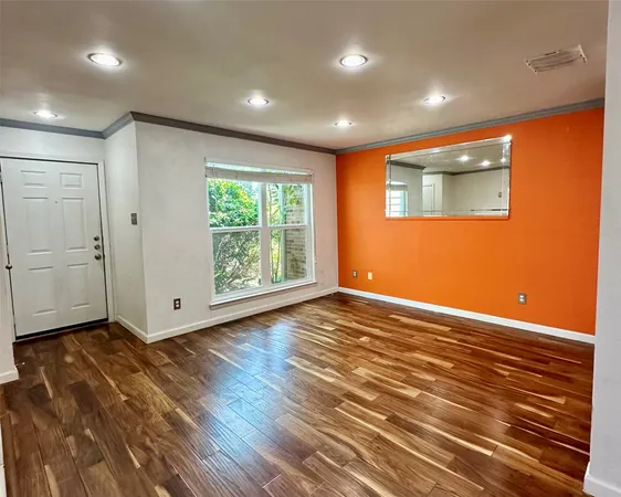 a view of a livingroom with wooden floor and a fireplace