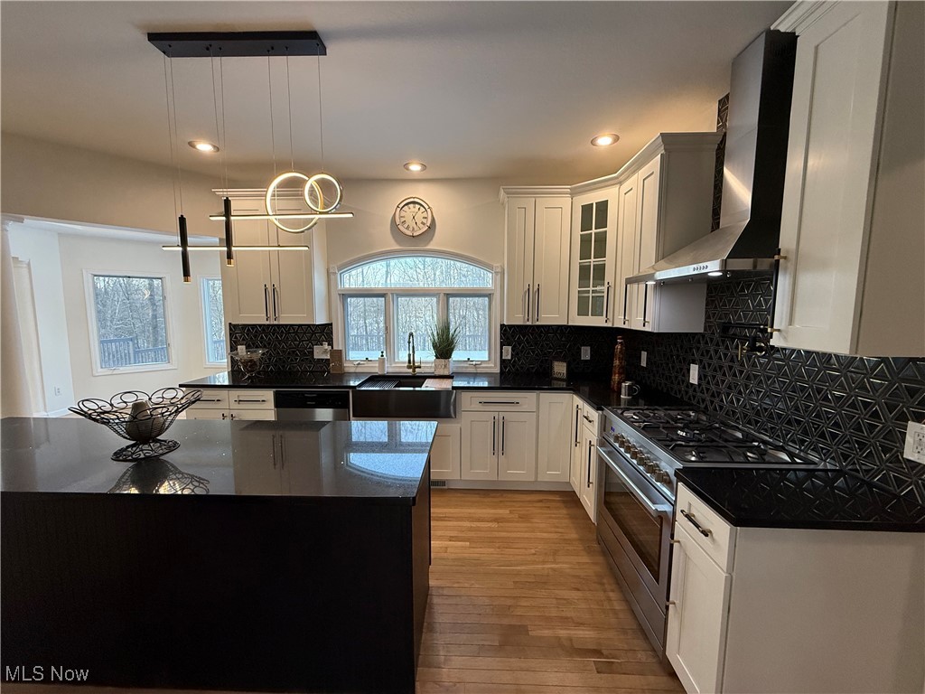 31295 Arthur Road Solon, OH 44139 - Photo 16 of 50 Kitchen featuring white cabinetry, sink, hanging light fixtures, stainless steel appliances, and wall chimney exhaust hood