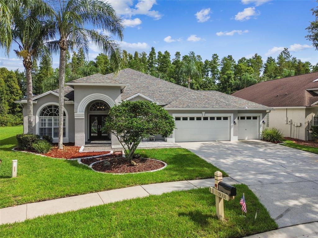 19331 Wind Dancer Street Lutz, FL 33558 - Photo 2 of 92 a view of house with garden and tall tree