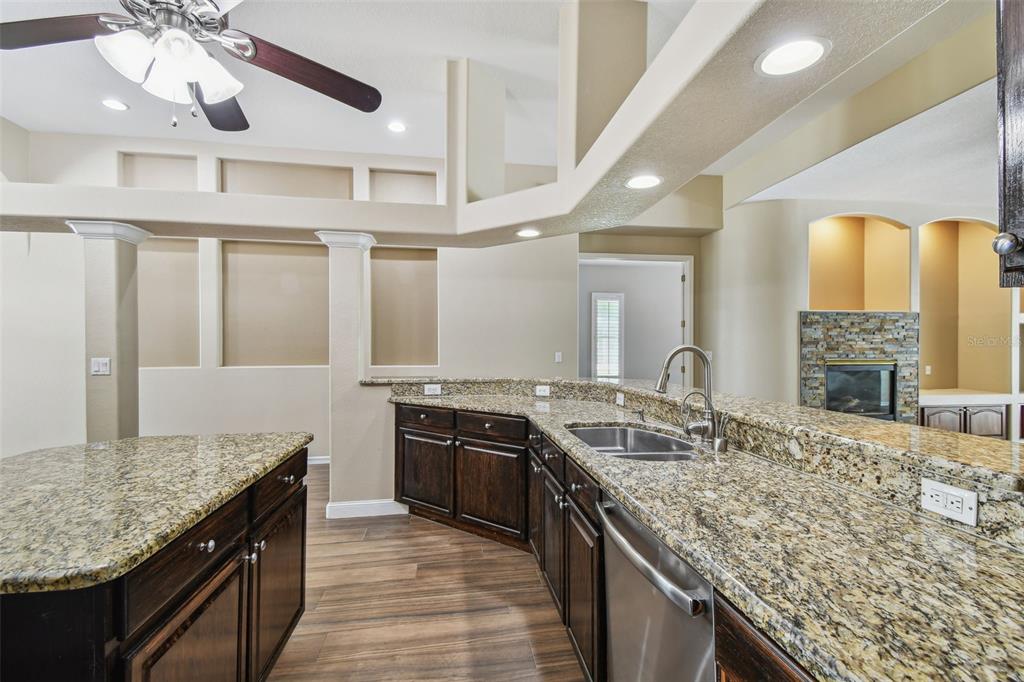 19331 Wind Dancer Street Lutz, FL 33558 - Photo 25 of 92 a kitchen with granite countertop kitchen island stainless steel appliances a sink stove and cabinets