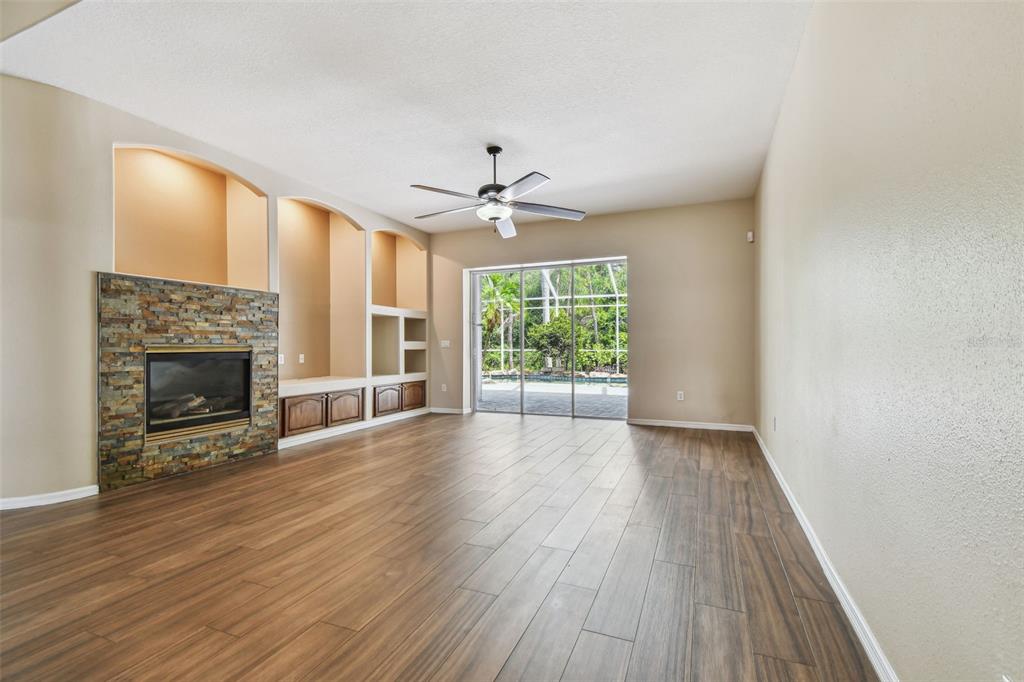 19331 Wind Dancer Street Lutz, FL 33558 - Photo 33 of 92 wooden floor fireplace and windows in an empty room