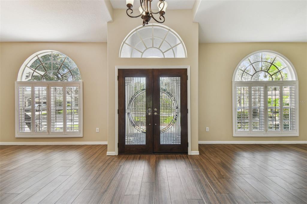 19331 Wind Dancer Street Lutz, FL 33558 - Photo 10 of 92 an empty room with wooden floor a mirror and a large window