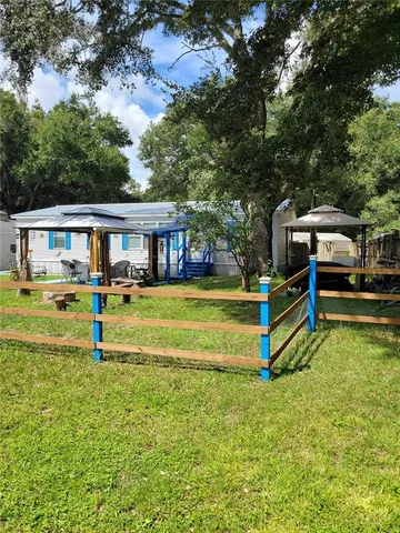 a view of a fountain in front of a house with a big yard