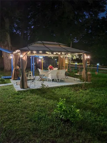 a front view of a house with garden and trees
