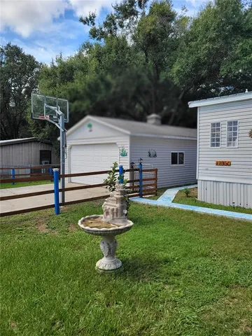 a backyard of a house with a garden and barbeque oven