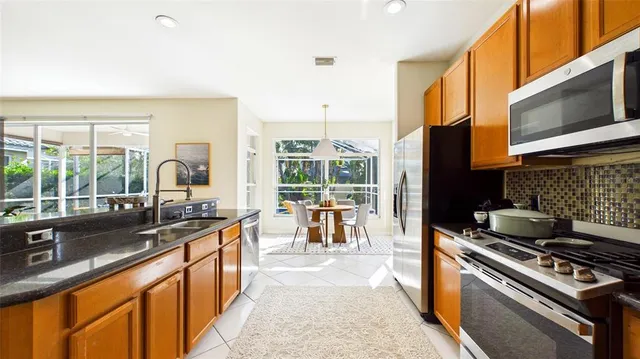 a kitchen with stainless steel appliances granite countertop a sink a stove and a refrigerator
