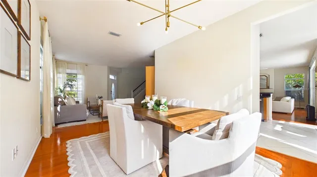 a kitchen with stainless steel appliances a stove a sink a microwave a dining table and chairs