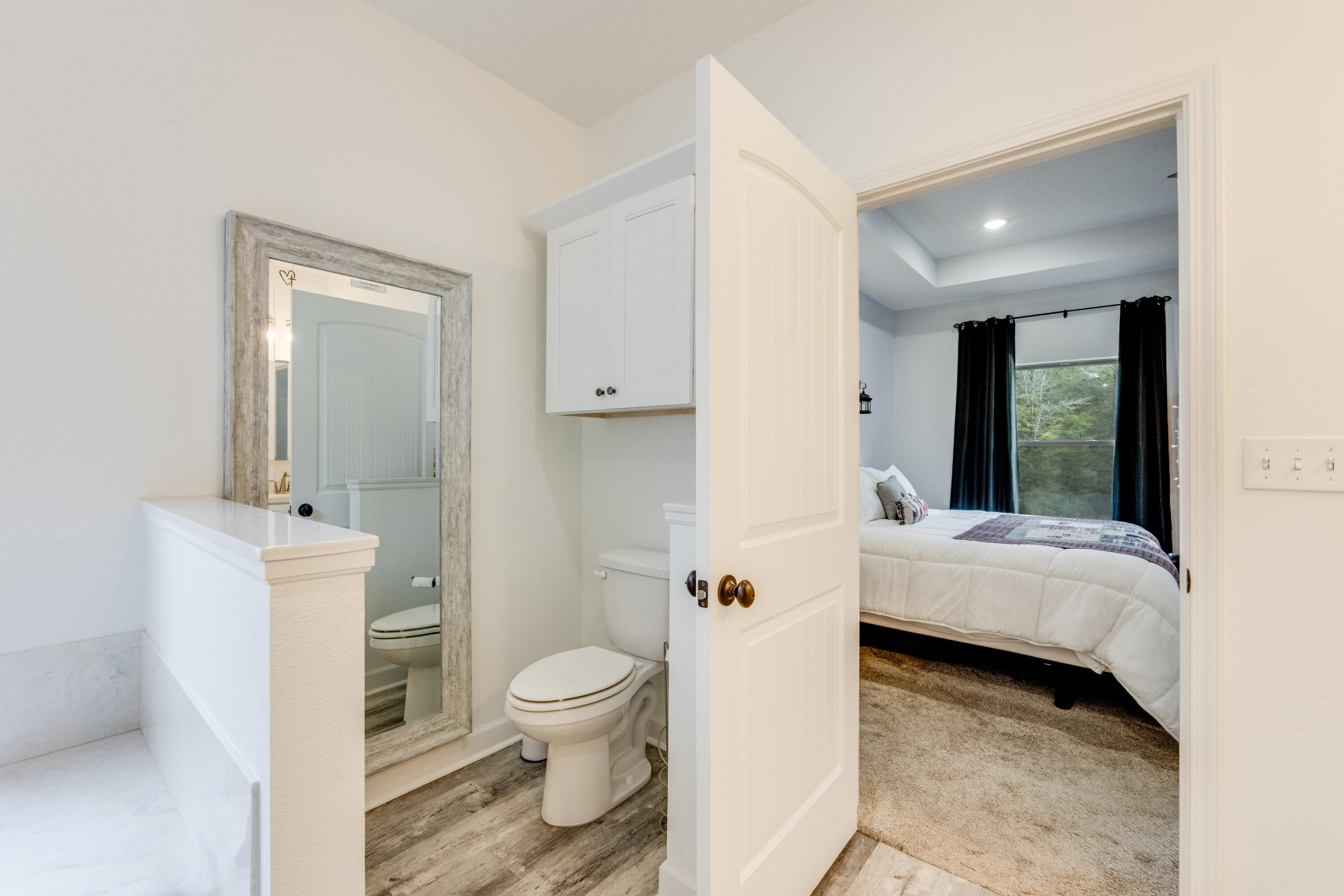 4444 Wilkerson Bluff Road Holt, FL 32564 - Photo 13 of 32 a bathroom with a toilet a sink and a large mirror