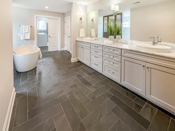 a spacious bathroom with a double vanity sink a mirror and a bathtub