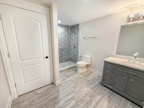 a bathroom with a sink a toilet and shower