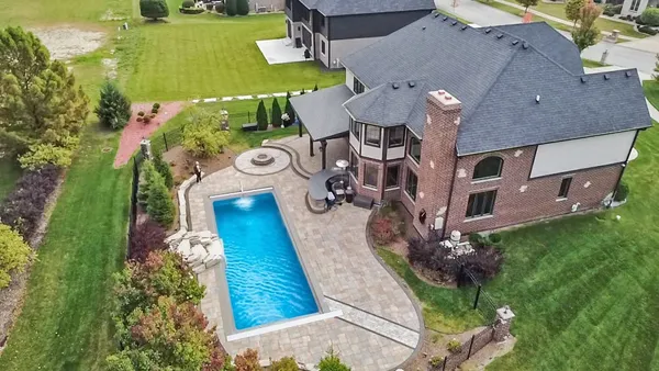 an aerial view of a house with swimming pool and garden