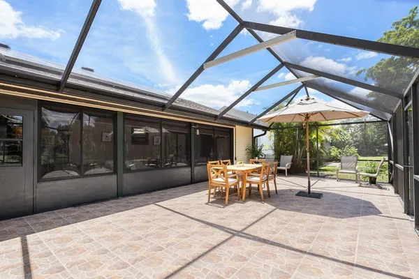a view of a patio with a table and chairs under an umbrella