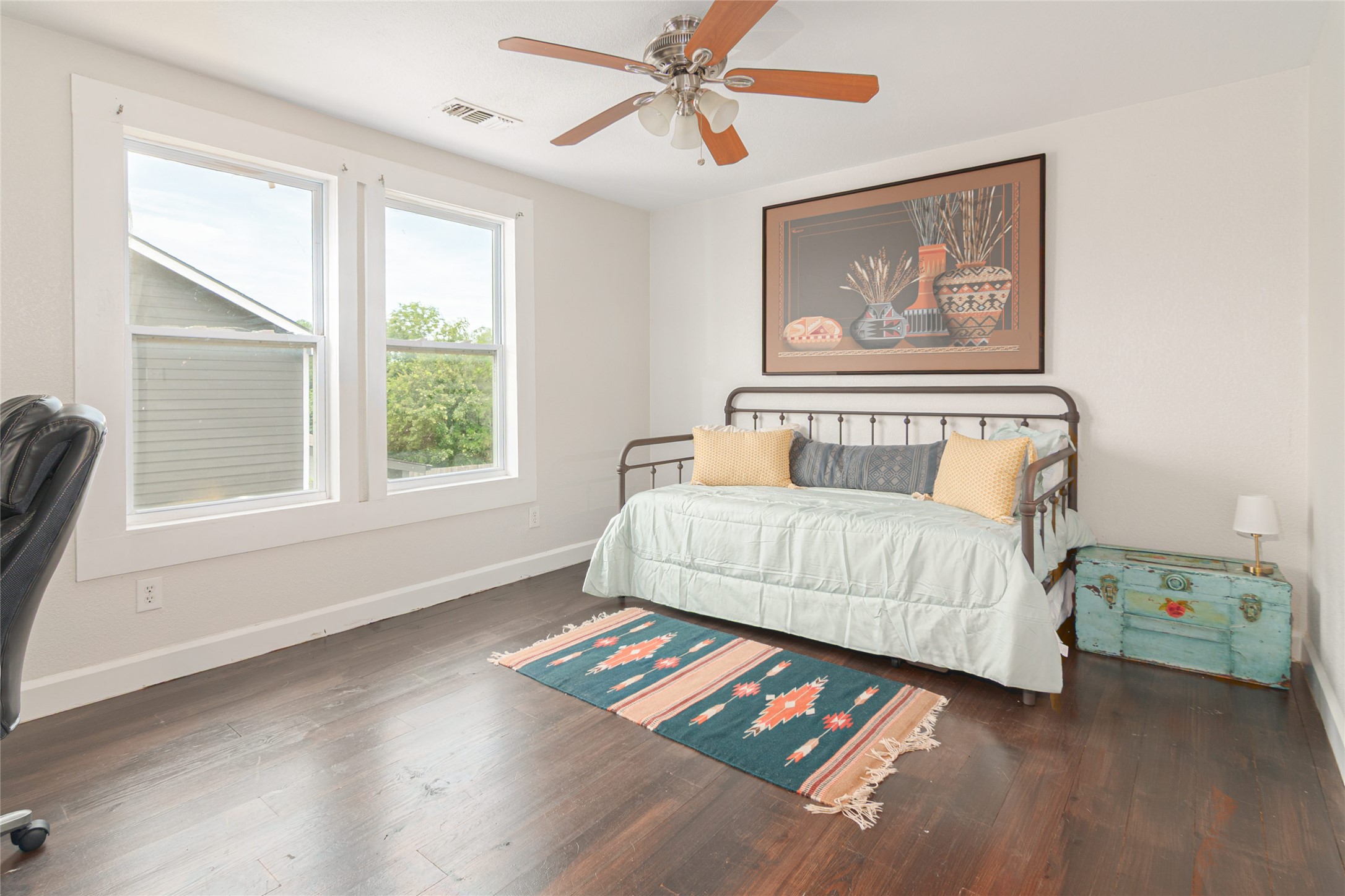 204 Prim Rose Road Blanco, TX 78606 - Photo 23 of 40 Rich dark wood floors ground this bedroom, illuminated by two large classic windows.